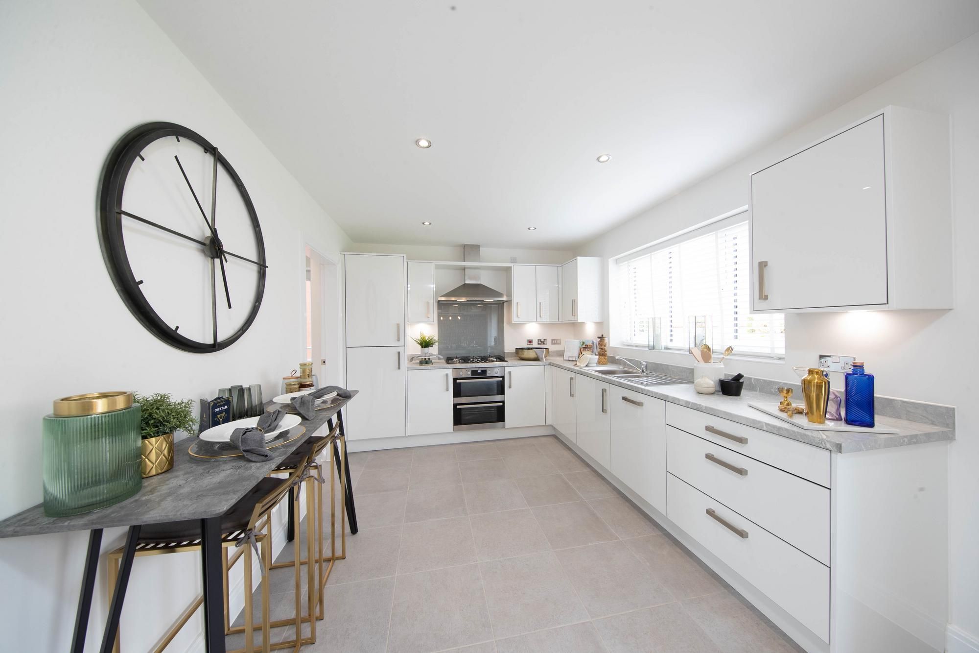 Compact kitchen with a large clock on the wall in the Newton in Kingsley Manor